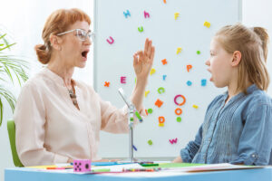 A-female-speech-language-therapist-teaching-a-child-vocal-exercises.jpg  